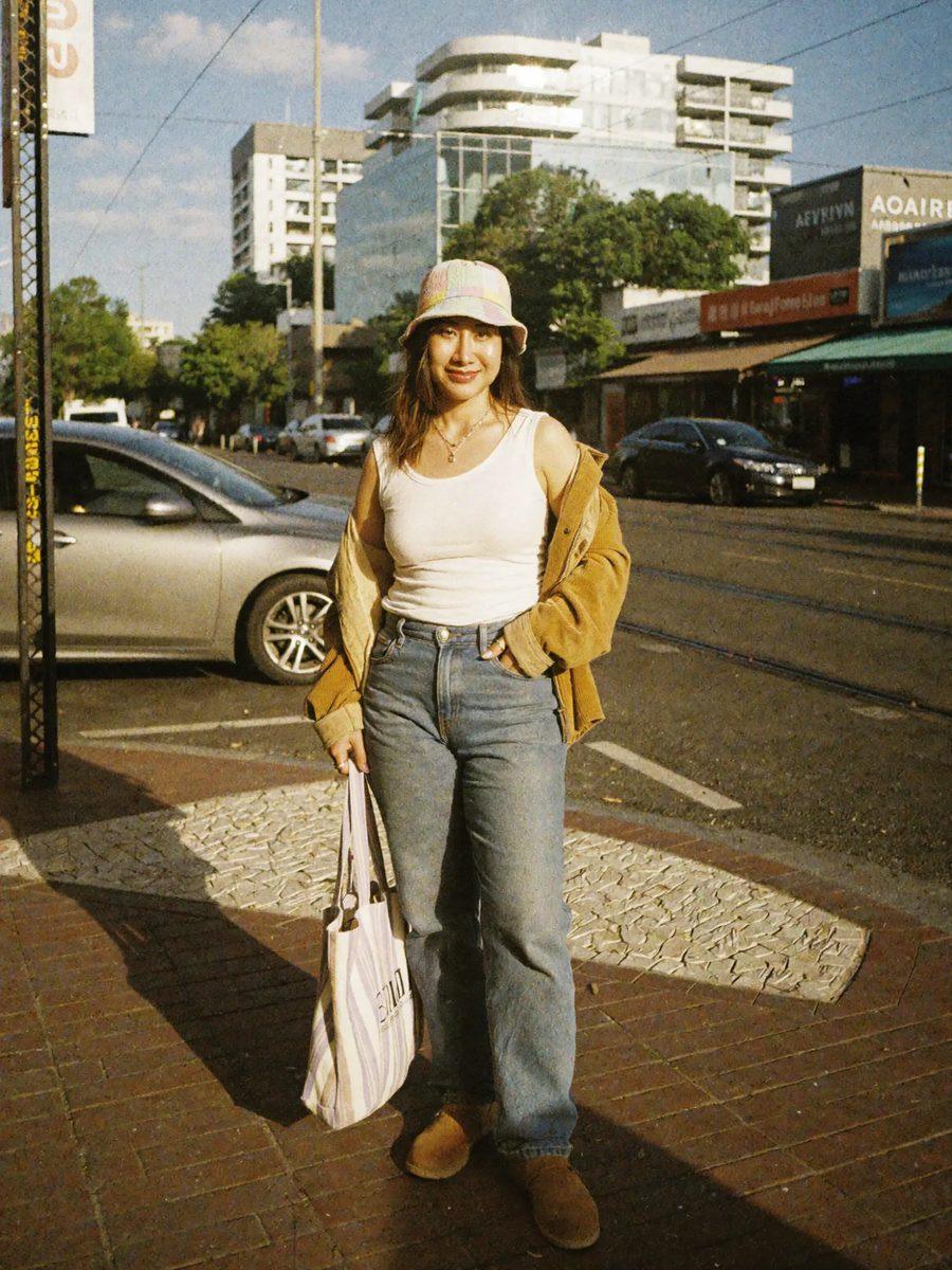 Real photo of Ami in a tan corduroy jacket, white tank and jeans